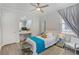 Bright bedroom featuring a ceiling fan, vanity, and a comfortable bed with decorative pillows at 11139 Camden Park Dr, Windermere, FL 34786