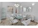Formal dining room features a modern glass table, sleek white chairs, and a mirrored accent wall at 11139 Camden Park Dr, Windermere, FL 34786
