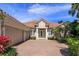 Charming one-story home with a well-manicured lawn, lush landscaping, and a brick driveway leading to a 3-car garage at 11139 Camden Park Dr, Windermere, FL 34786