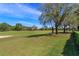 Scenic view of the meticulously maintained golf course with lush green grass and mature trees at 11139 Camden Park Dr, Windermere, FL 34786