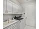 Efficient laundry room featuring modern washer/dryer units, ample cabinetry, and sink at 11139 Camden Park Dr, Windermere, FL 34786