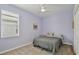 Small bedroom with simple furnishings, gray queen bed and a light lavender paint at 11725 Language Way, Orlando, FL 32832