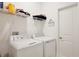 Bright Laundry room with side by side washer and dryer and wire rack storage at 11725 Language Way, Orlando, FL 32832