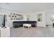 Bright living room with large black leather sectional sofa and modern gray tile floors at 11725 Language Way, Orlando, FL 32832