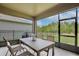 Screened-in lanai with table and chairs provides an outdoor dining space and backyard view at 11725 Language Way, Orlando, FL 32832