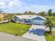 Aerial view of a charming single-story home with a well-manicured lawn and attached garage at 120 Sand Dunes Dr, Ormond Beach, FL 32176