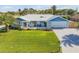 Charming one-story home featuring a well-manicured lawn, white picket fence and an attached garage at 120 Sand Dunes Dr, Ormond Beach, FL 32176