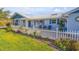 Inviting front porch with brick flooring, a picket fence, and charming outdoor decor at 120 Sand Dunes Dr, Ormond Beach, FL 32176