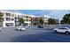 Exterior of the complex with ample parking, retail storefronts, and modern architectural details under a bright sky at 1244 Water Maple Dr, Oakland, FL 34787