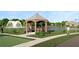A picturesque view of a community gazebo by the water with a fountain creating a relaxing atmosphere at 1256 Water Maple Dr, Oakland, FL 34787
