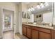Bathroom features a double sink vanity with granite countertop and an inviting doorway to an outdoor patio at 1405 Thunderbird Rd, Davenport, FL 33896