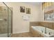 Bathroom boasts a separate shower and soaking tub, complemented by tile flooring and a decorative window at 1405 Thunderbird Rd, Davenport, FL 33896