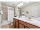 Bright bathroom with double sinks, a large mirror, and a shower with a curtain at 1405 Thunderbird Rd, Davenport, FL 33896