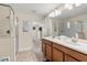 Bathroom featuring double sinks, a glass shower, and neutral tile flooring at 1405 Thunderbird Rd, Davenport, FL 33896