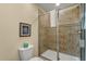 Tiled bathroom with a glass-enclosed shower, toilet, and coordinated decor at 1405 Thunderbird Rd, Davenport, FL 33896