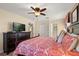 Comfortable bedroom featuring a ceiling fan, dresser, and red and white patterned bedding at 1405 Thunderbird Rd, Davenport, FL 33896