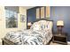 Cozy bedroom features a plush bed, dark wood furniture, stylish lamps, and a serene blue accent wall at 1405 Thunderbird Rd, Davenport, FL 33896