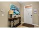 Inviting entryway featuring a console table with a lamp and artwork, adjacent to the front door at 1405 Thunderbird Rd, Davenport, FL 33896