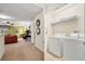Hallway view with laundry closet featuring a washer, dryer, and storage shelves at 1405 Thunderbird Rd, Davenport, FL 33896