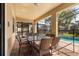 Covered patio with a dining table and a view of the pool, perfect for entertaining at 1405 Thunderbird Rd, Davenport, FL 33896