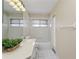 Bright bathroom with white tile floors, bathtub, and vanity with a plant at 14313 Roxshire Dr, Orlando, FL 32837