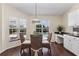 Cozy breakfast nook with hardwood floors, windows overlooking the pool, and white cabinets at 14313 Roxshire Dr, Orlando, FL 32837