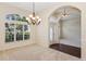 Lovely dining room with a chandelier, archway, large window, and neutral carpet and flooring at 14313 Roxshire Dr, Orlando, FL 32837
