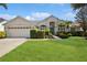 Charming single-story home with a lush green lawn, manicured hedges, and a welcoming front entrance at 14313 Roxshire Dr, Orlando, FL 32837