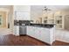 Stylish kitchen with stainless steel appliances, dark granite countertops, white cabinets, and hardwood floors at 14313 Roxshire Dr, Orlando, FL 32837