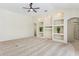 Spacious living room featuring neutral carpet, a ceiling fan, and charming built-in shelving with plants at 14313 Roxshire Dr, Orlando, FL 32837