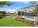 Screened-in pool overlooking a pond with well-manicured lawn, and garden in this delightful backyard at 14313 Roxshire Dr, Orlando, FL 32837