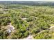 Wide aerial view of sprawling wooded property and surrounding landscape, including other homes in the distance at 145 Baywood Dr, Oak Hill, FL 32759