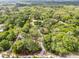 An aerial view of the property surrounded by lush trees and a long driveway to the home at 145 Baywood Dr, Oak Hill, FL 32759