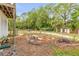 Landscaped backyard with trees, bench seating, brick pavers and mulched ground cover with a clothes line at 145 Baywood Dr, Oak Hill, FL 32759