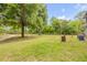 Spacious backyard features a large shade tree and a lush green lawn perfect for outdoor activities at 145 Baywood Dr, Oak Hill, FL 32759