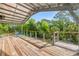 Open-air deck with natural wood floors, cable railing, and outdoor seating with scenic forest views at 145 Baywood Dr, Oak Hill, FL 32759