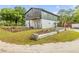 Two-story barndominium with fenced garden, gray and green siding, and a small balcony overlooking yard at 145 Baywood Dr, Oak Hill, FL 32759