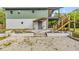 Front entrance of the home with purple door, stone steps, minimalist garden, and rock and gravel path at 145 Baywood Dr, Oak Hill, FL 32759