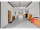 Long, open garage space featuring an overhead door, exposed ceiling, and some storage on the sides at 145 Baywood Dr, Oak Hill, FL 32759