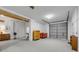 Spacious garage with a ceiling fan, workbench, and cabinets with a painted concrete floor at 145 Baywood Dr, Oak Hill, FL 32759