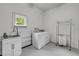 Bright laundry room features a utility sink, washer, and dryer, with natural light from the window at 145 Baywood Dr, Oak Hill, FL 32759