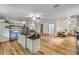Open-concept living area featuring wood-look floors, light walls, and a glimpse into other spaces of the home at 145 Baywood Dr, Oak Hill, FL 32759