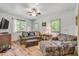Cozy living room with wood-look floors, a comfortable sofa and arm chair, and plenty of natural light at 145 Baywood Dr, Oak Hill, FL 32759