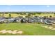 An aerial view shows homes lining a golf course with sand traps and the surrounding community at 1539 Corolla Ct, Reunion, FL 34747