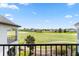 Upper-level balcony view overlooking the golf course and neighboring homes under a sunny sky at 1539 Corolla Ct, Reunion, FL 34747
