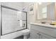 Clean and modern bathroom featuring a shower-over-tub with a glass door and a white vanity sink at 1539 Corolla Ct, Reunion, FL 34747