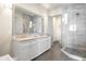 Elegant bathroom featuring dual sinks, granite countertops, a modern shower, and stylish lighting at 1539 Corolla Ct, Reunion, FL 34747