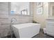 Close-up of a modern bathtub with stylish fixtures, set against a backdrop of elegant tile work at 1539 Corolla Ct, Reunion, FL 34747