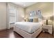 Bright bedroom featuring hardwood floors, a large bed, and stylish decor at 1539 Corolla Ct, Reunion, FL 34747