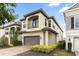 A two-story home featuring neutral stucco, a clay tile roof, and a spacious garage with brick-paved driveway at 1539 Corolla Ct, Reunion, FL 34747